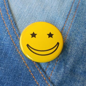 Ansteckbutton Smiley Sternchenaugen gelb auf Jeans